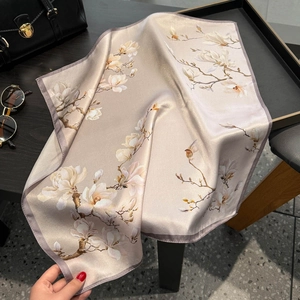 Close-up of premium champagne silk square scarf with elegant magnolia floral pattern
