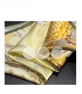 Macro detail showing smooth glossy silk texture and yellow chrysanthemum floral pattern