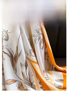 Détail d'un foulard en soie avec texture satinée lisse et imprimé floral de lys