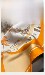 Gros plan sur l'ourlet roulé délicat et l'imprimé fleuri du foulard en soie
