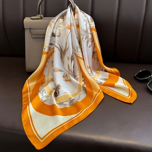 Détail d'un foulard en soie fleurie attaché sur un sac à main en cuir de luxe chic