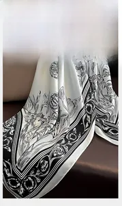 Close-up of elegant floral print silk scarf with fine edge stitching on leather