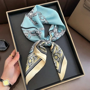 Elegant light blue and beige silk scarf featuring vintage floral patterns on a tray