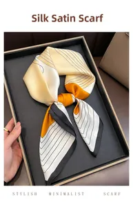 Close-up of knotted satin silk square scarf with orange and black geometric pattern