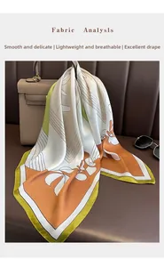 Detail of elegant silk scarf with geometric floral pattern draped on a leather bag
