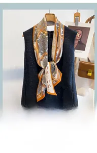 Detail of a paisley silk-feel long neck scarf styled with a black sequin dress