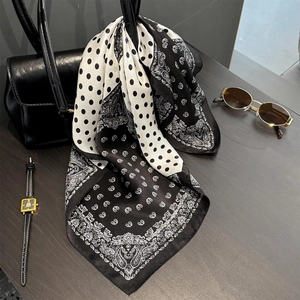 Polka dot and paisley silk neckerchief styled on a black leather handbag with accessories