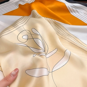 Detailed view of the smooth satin texture and elegant floral patterns on this square scarf