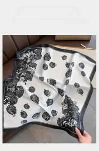 Close-up of silk-feel square scarf featuring artistic rose prints on a premium leather base