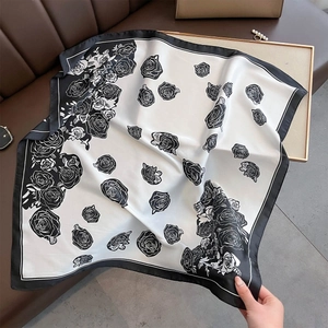 Elegant faux silk square scarf with realistic rose print and black border on a sofa