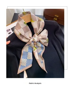 Détail d'un foulard en soie à fleurs noué sur un pull noir avec analyse du tissu