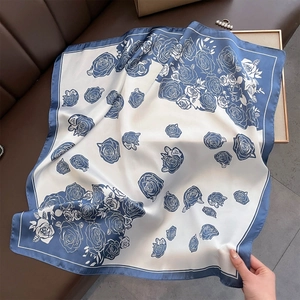 Detail of silk-satin scarf showing elegant blue and white rose print with premium drape