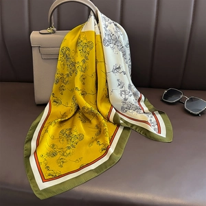 Floral silk square scarf with yellow and white patchwork draped over a handbag
