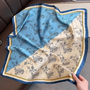Close-up of sky blue and beige floral silk scarf with elegant dark blue border