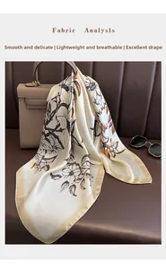 Floral silk scarf draped on a leather handbag with sunglasses for an elegant look