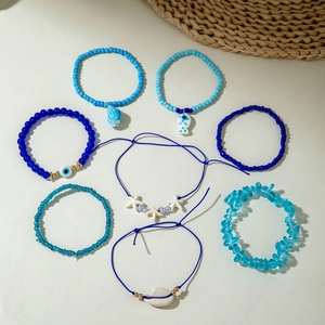 Detailed set of seven bohemian blue beaded bracelets with starfish and shell charms