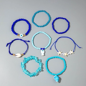 Detail of 8-piece ocean themed bead bracelet set with starfish and shell charms