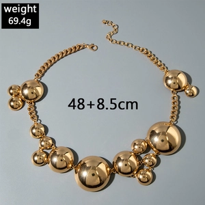 Detail of chunky gold chain necklace with polished spherical pendants and adjustable clasp
