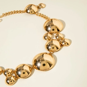 Golden chunky chain necklace with bold geometric spherical pendants in a retro style