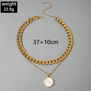 Detailed view of layered gold Curb chain necklace with a white pearl pendant