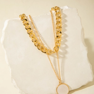 Double-layered gold geometric necklace featuring a curb chain and white shell round pendant