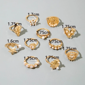Detail view of 10-piece gold pearl ring set with shell and starfish charms