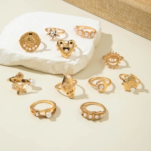 Detailed macro shot of 10 gold bohemian rings with pearls and ocean shell motifs