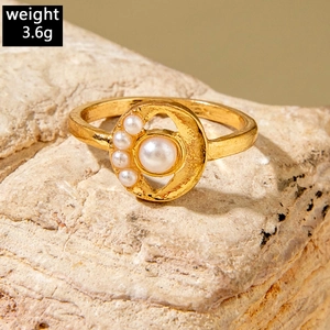 Macro shot of gold pearl ring with a large center pearl and four side pearls on a stone