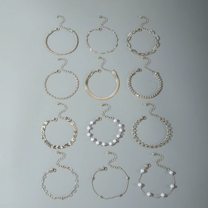 Coffret de 12 bracelets dorés avec perles, strass et divers types de chaînes maillons
