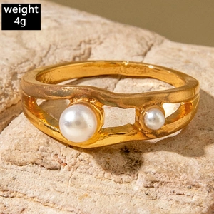 Detailed macro view of wave-shaped gold pearl ring weighing 4g on a stone base