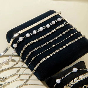 Vue détaillée d'un ensemble de bracelets argentés avec perles et chaîne serpent sur velours
