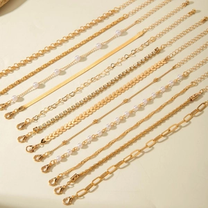 Détails d'un ensemble de 12 bracelets dorés avec perles, strass et mailles variées