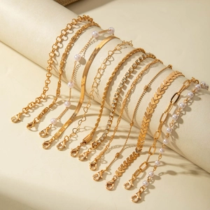 Détails d'un ensemble de 11 bracelets dorés avec perles et strass sur présentoir
