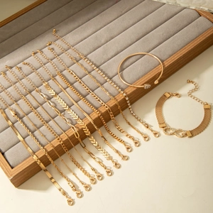 Détail d'un ensemble de 13 bracelets dorés ornés de perles et de strass brillants