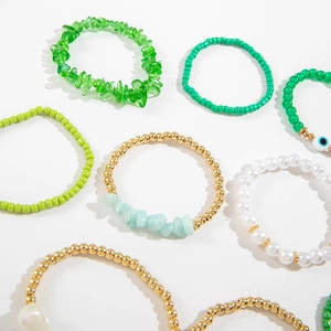 Set de bracelets bohèmes verts avec perles et œil protecteur sur fond blanc éclatant