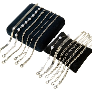 Ensemble de bracelets argentés multicouches avec perles et strass sur coussin noir
