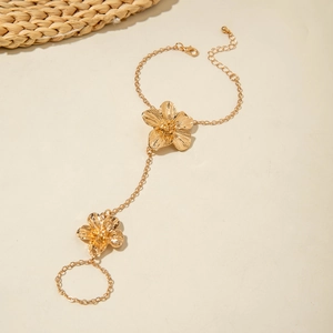 Detailed view of a gold floral finger bracelet featuring delicate petals and thin chain