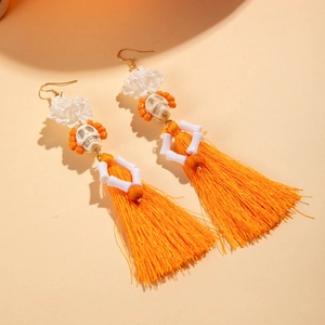Détails de boucles d'oreilles tête de mort avec franges orange et dentelle blanche