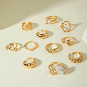 Macro view of gold alloy rings set featuring irregular liquid metal textures and pearl accents
