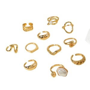 11-piece set of gold vintage geometric hollow rings with baroque pearls on white background
