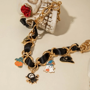 Detail of Halloween choker with gold chain and ghosts pumpkin pendants on dark rose decor