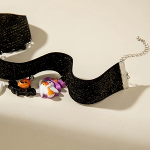 Detail of Halloween choker featuring bat pumpkin and ghost pendants on black glitter ribbon