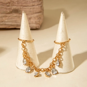 Bague double dorée avec chaîne et pendentifs en forme de gouttes sur supports élégants