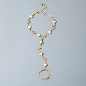 Détails du bracelet bague doré orné de perles blanches et d'un motif floral rose ajouré