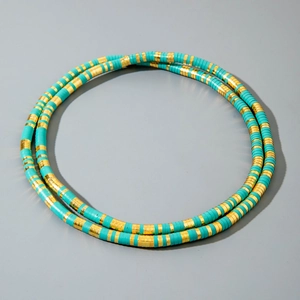 Detail of bohemian turquoise and gold heishi bead necklace with textured metal spacers