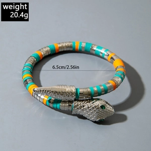 Close-up of silver snake necklace featuring green gemstone eyes and textured scales