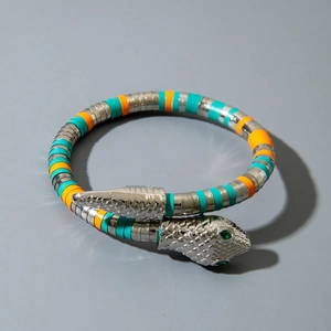 Detailed view of silver snake necklace with blue and orange enamel scales and green zircon eyes