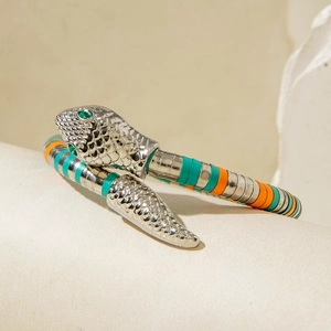 Close-up of snake bracelet with green gemstone eyes and colorful beaded metal scales