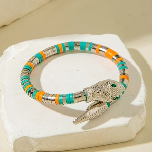 Close-up of tricolor snake bracelet featuring green gem eyes and scale texture details