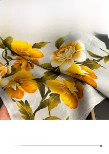 Detail of silk scarf with fine edge stitching and vibrant yellow floral patterns